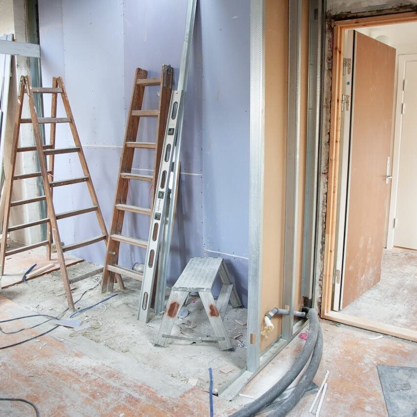 Construction site featuring ladders and tools in a home renovation setting.